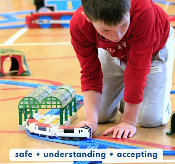 Image of child playing with train with words: Safe, Understanding, Accepting