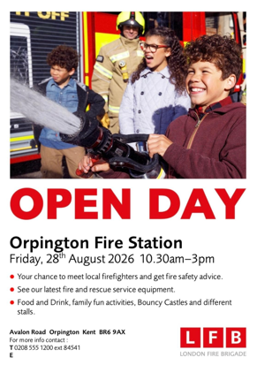 Child standing around child holding hose spraying water next to red fire engine