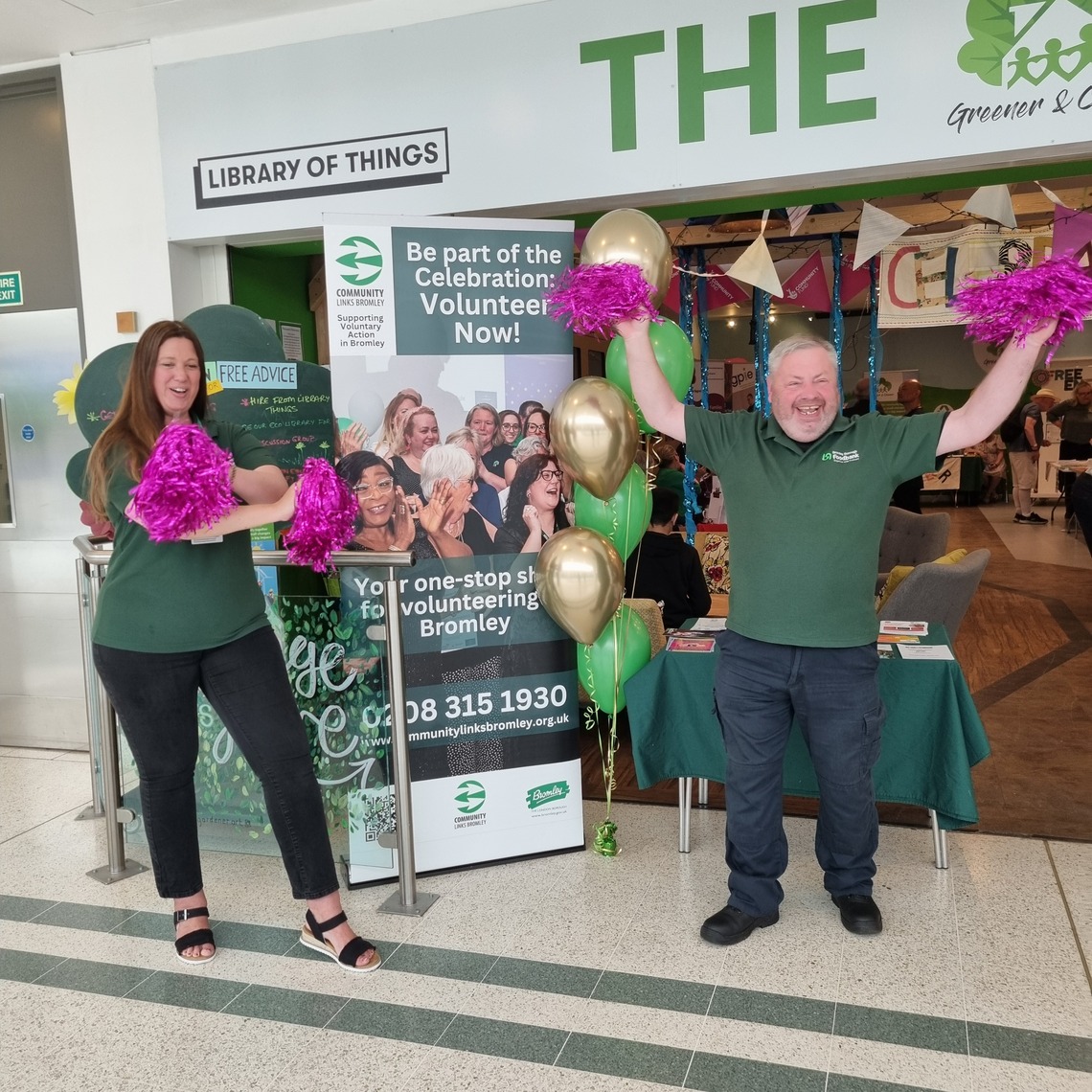 Staff members from Bromley Borough Foodbank standing with pink pom poms in their hands
