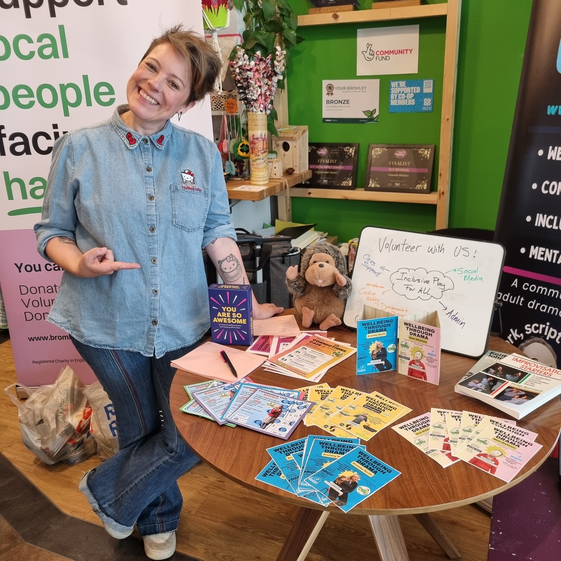 Staff member from Quest Soul Theatre standing next to table with leaflets about charity