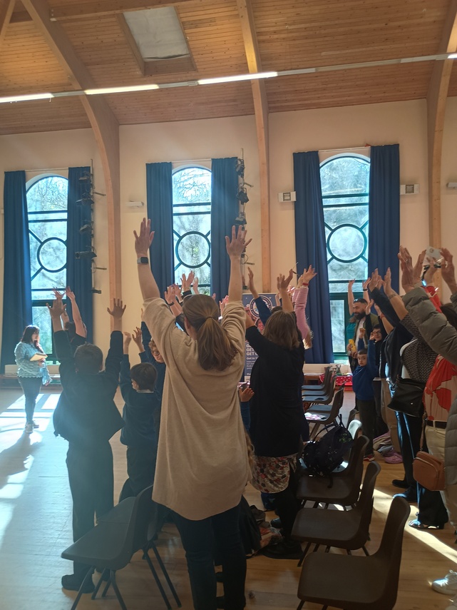 People standing in hall with raised hands