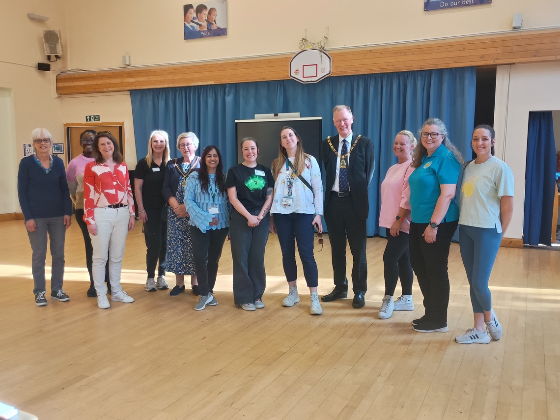 People standing in a line in hall, alongside Mayor of Bromley, smiling for camera