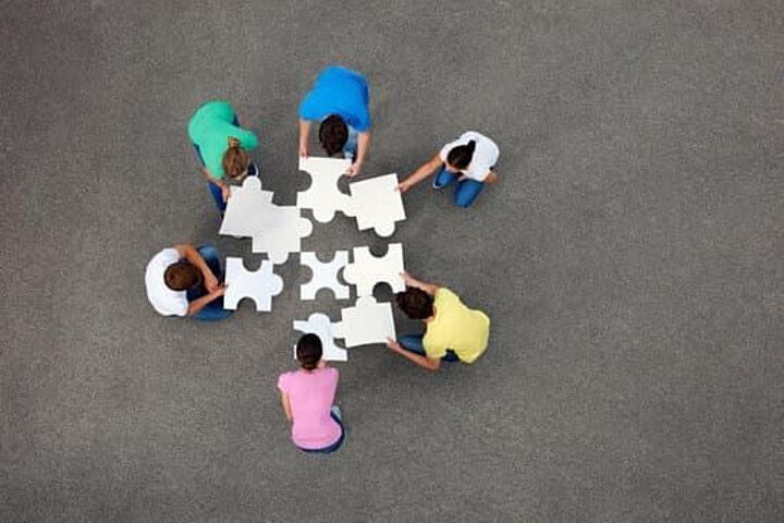Image of people putting puzzle pieces together