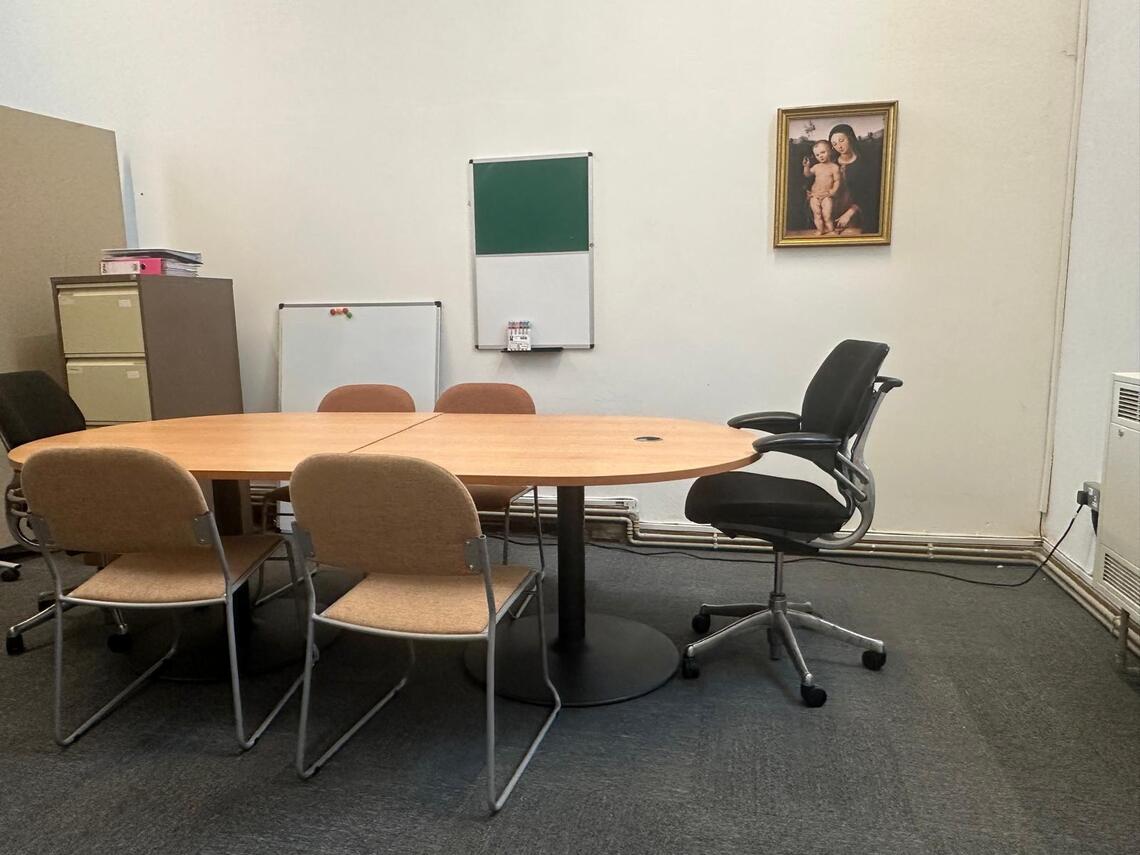 Room with table surrounded by chairs